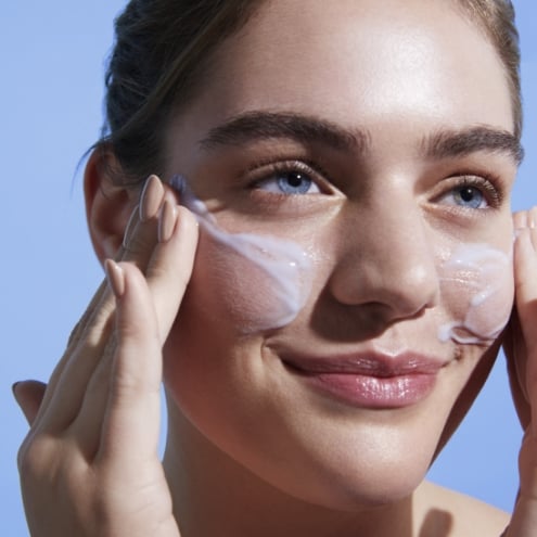 Woman applying face cleanser